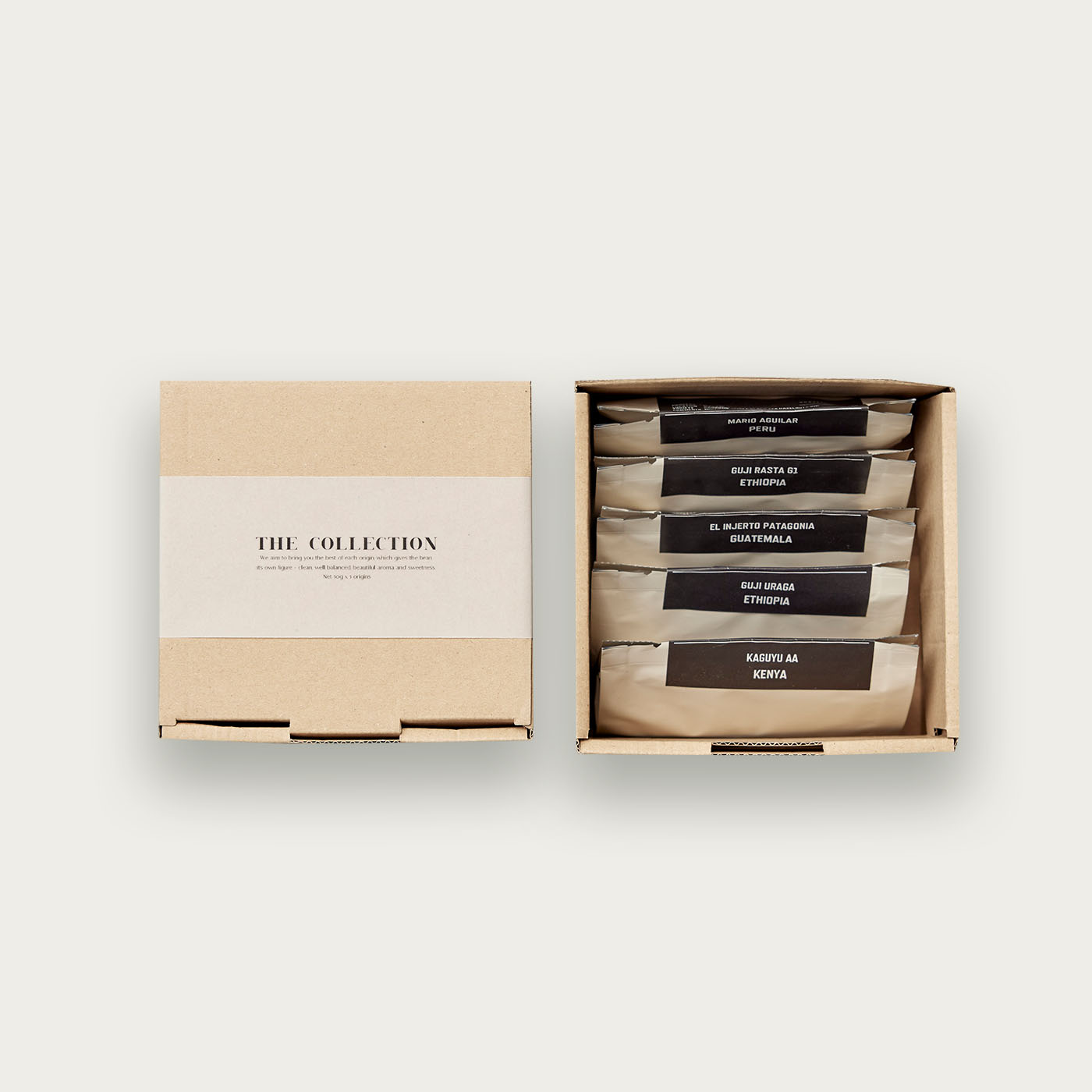A cardboard box labeled "THE COLLECTION" next to an open box showing several sealed packets of coffee.