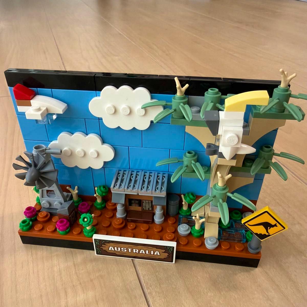 Assembled LEGO 40651 Australia model displayed on a wooden floor showing a blue backdrop, trees, windmill, and an "AUSTRALIA" nameplate.