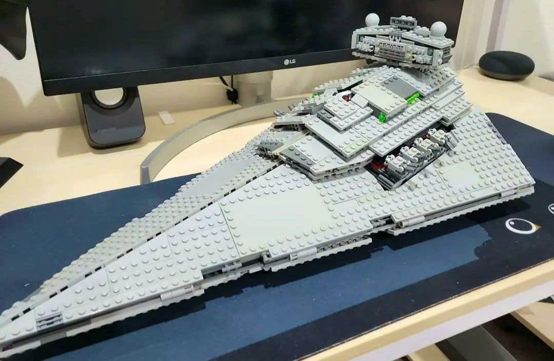 Assembled LEGO Star Wars 75055 Imperial Star Destroyer model displayed on a desk in front of a monitor.