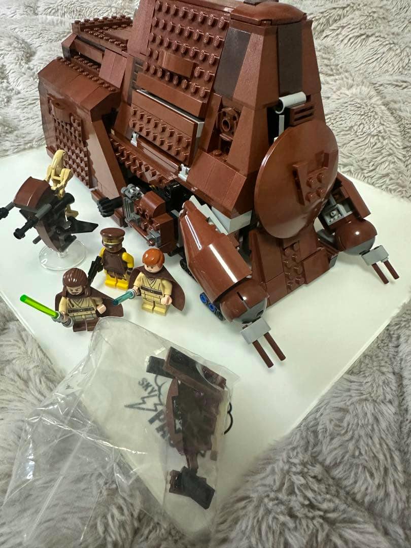 Assembled brown LEGO Star Wars 75058 model shown with minifigures and a small plastic parts bag on a white surface.