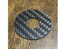 Round carbon-pattern dust washer with a central hole for the JLX/JLF lever, shown on a wooden surface.