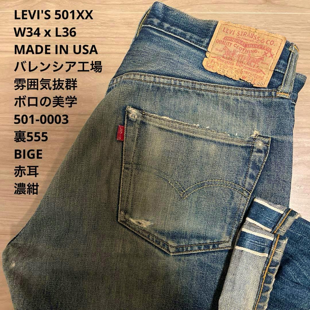 Folded Levi's 501 men's blue denim jeans showing the back pocket with red tab, visible leather patch, and selvedge cuff.