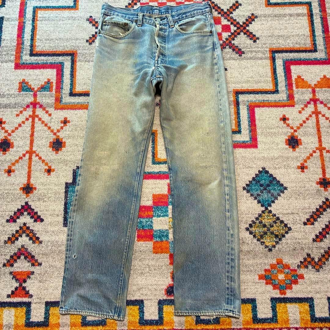 Levi's 501 men's jeans (W32) laid flat full-length on a colorful patterned rug.