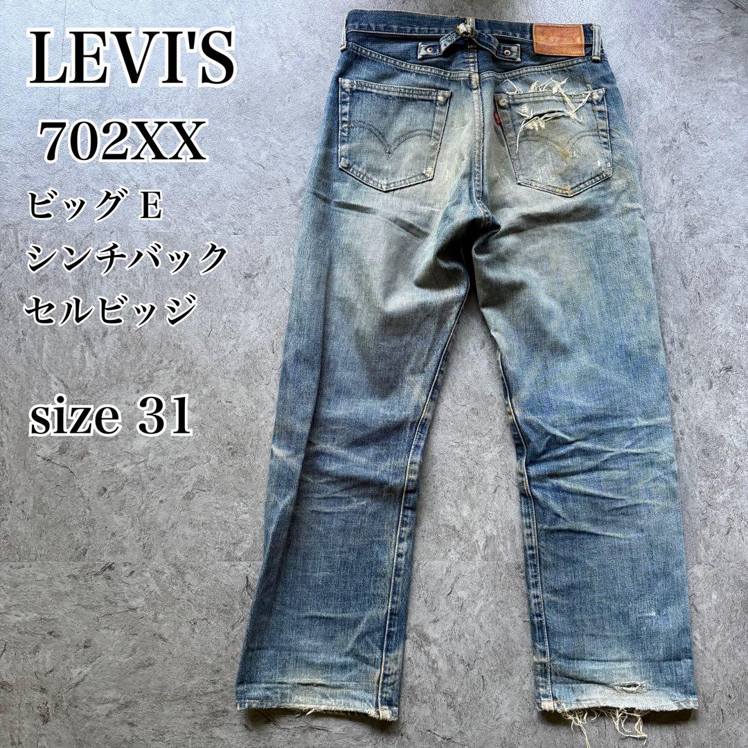 Back view of a pair of worn Levi's men's jeans laid flat showing a cinchback and leather patch.