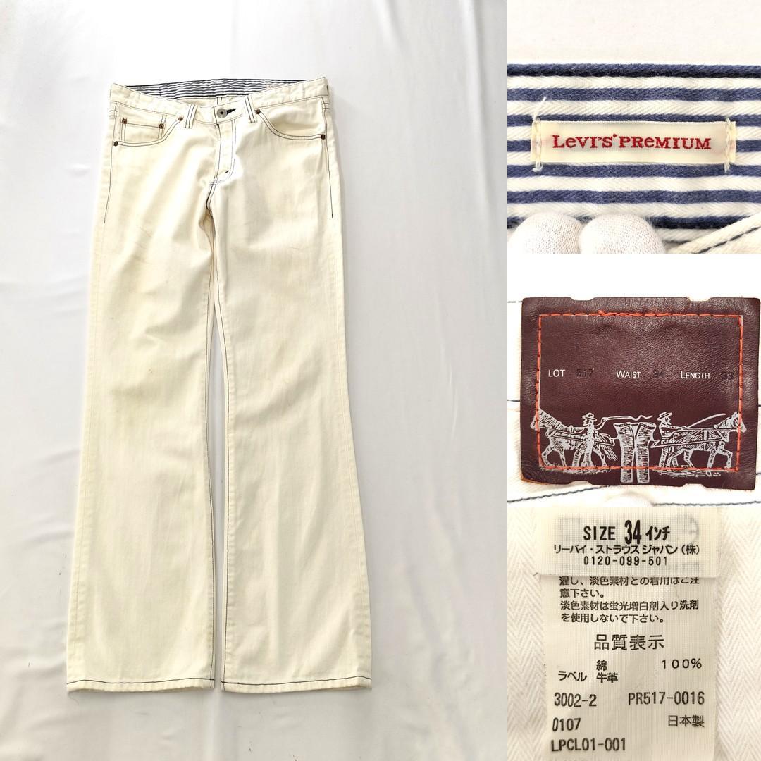 White Levi's Premium 517 bootcut denim pants laid flat with close-up shots of the Levi's label, leather patch, and care tag.