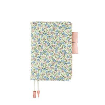 A cotton A6 book cover in Liberty Fabrics Sasha Kiora floral print with a pink pen loop and two pink-tipped ribbon bookmarks on a white background.
