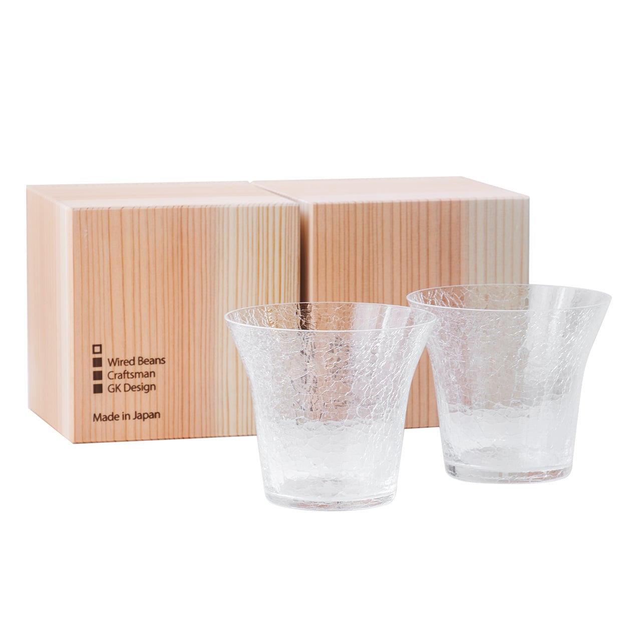 Two clear crackle-pattern rock tumblers displayed in front of two gift boxes.
