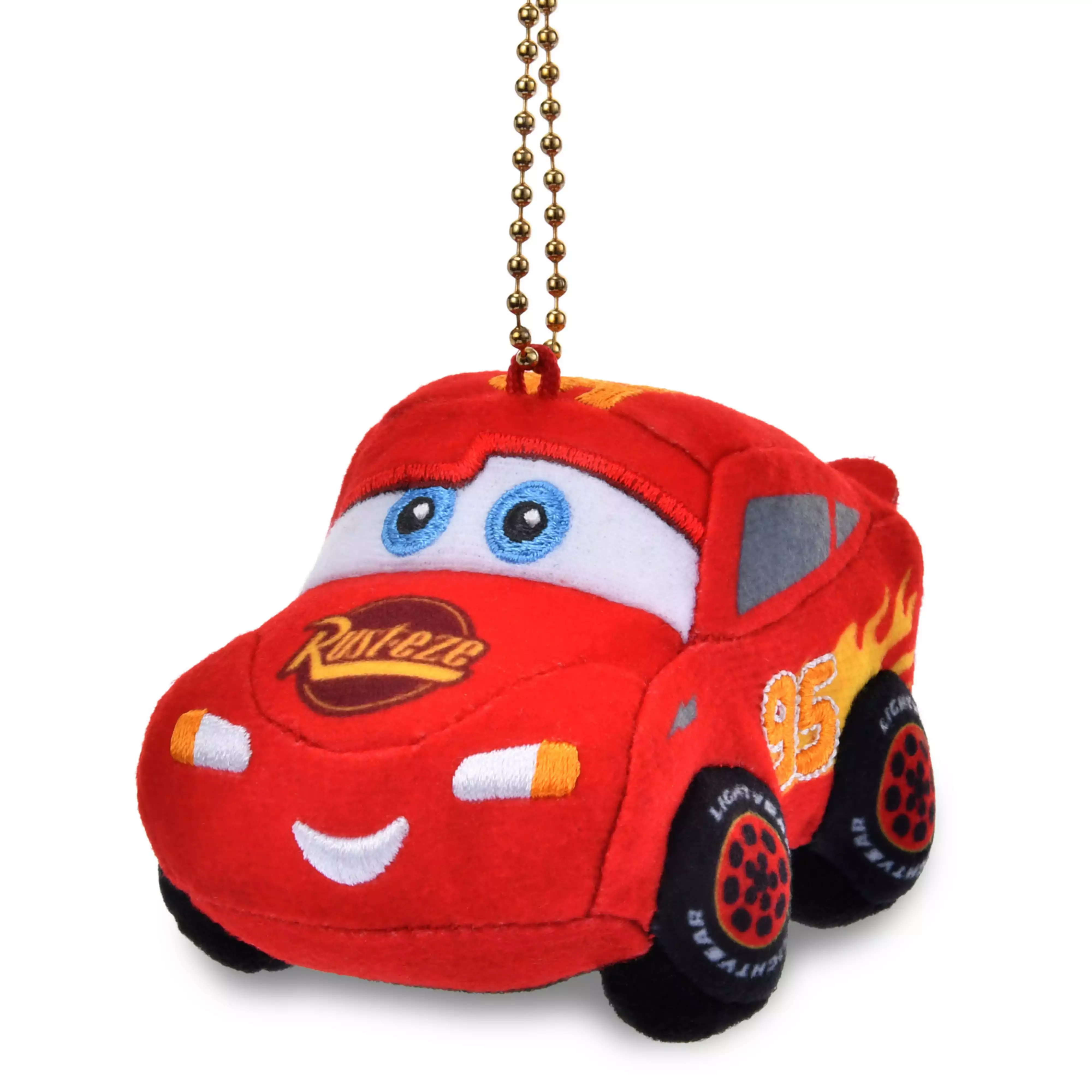 A red Lightning McQueen plush keychain with a gold ball chain, showing embroidered eyes, smile, and printed wheels.