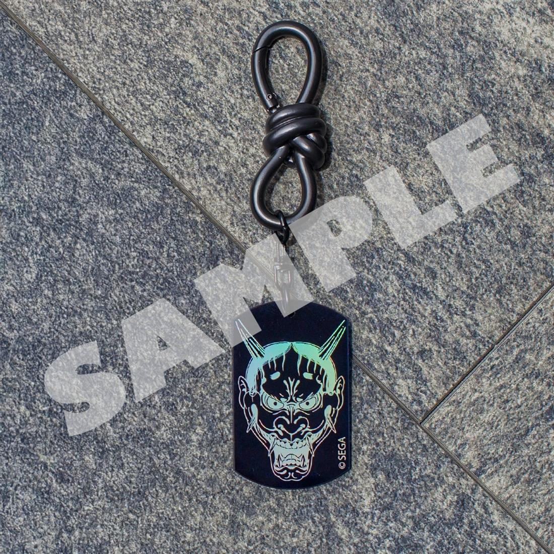 An aurora acrylic keychain for 『龍が如く』 showing Majima Gorō's Hannya mask design attached to a black clasp, photographed on a gray tiled background with a SAMPLE watermark.