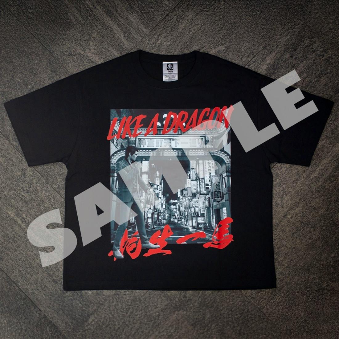 Black M-size cotton T-shirt laid flat showing a Kamurocho art city-street print with a standing man, red "LIKE A DRAGON" text, and a diagonal "SAMPLE" watermark.