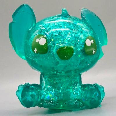 Front view of a translucent teal glittery Stitch squeeze figure.