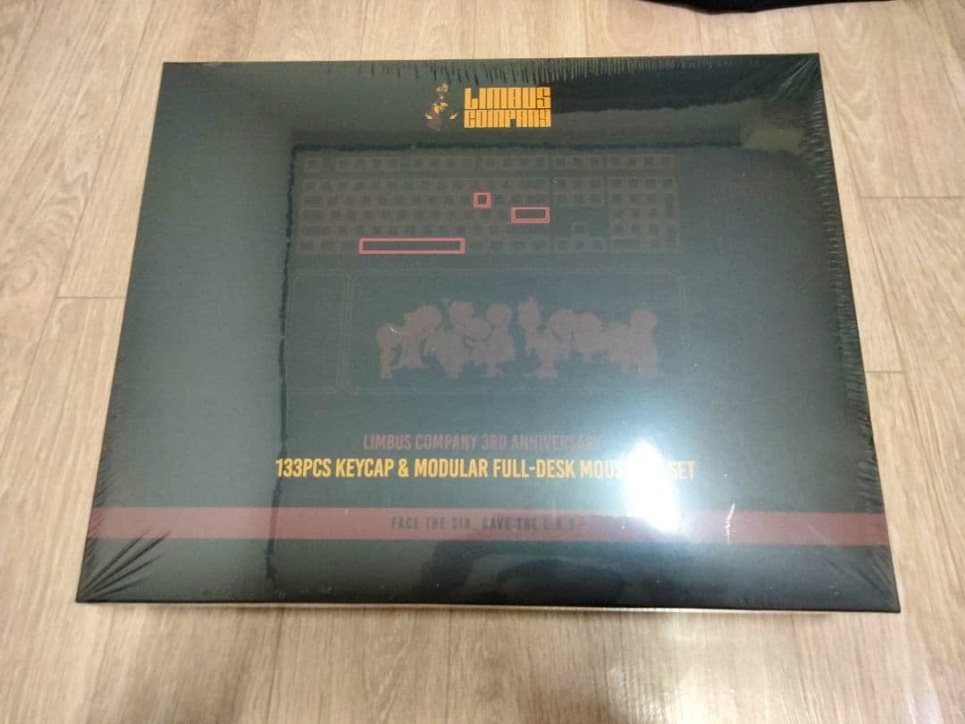 Sealed Limbus Company 3rd Anniversary 133-piece keycap and modular full-desk mouse set retail box placed on a wooden floor.