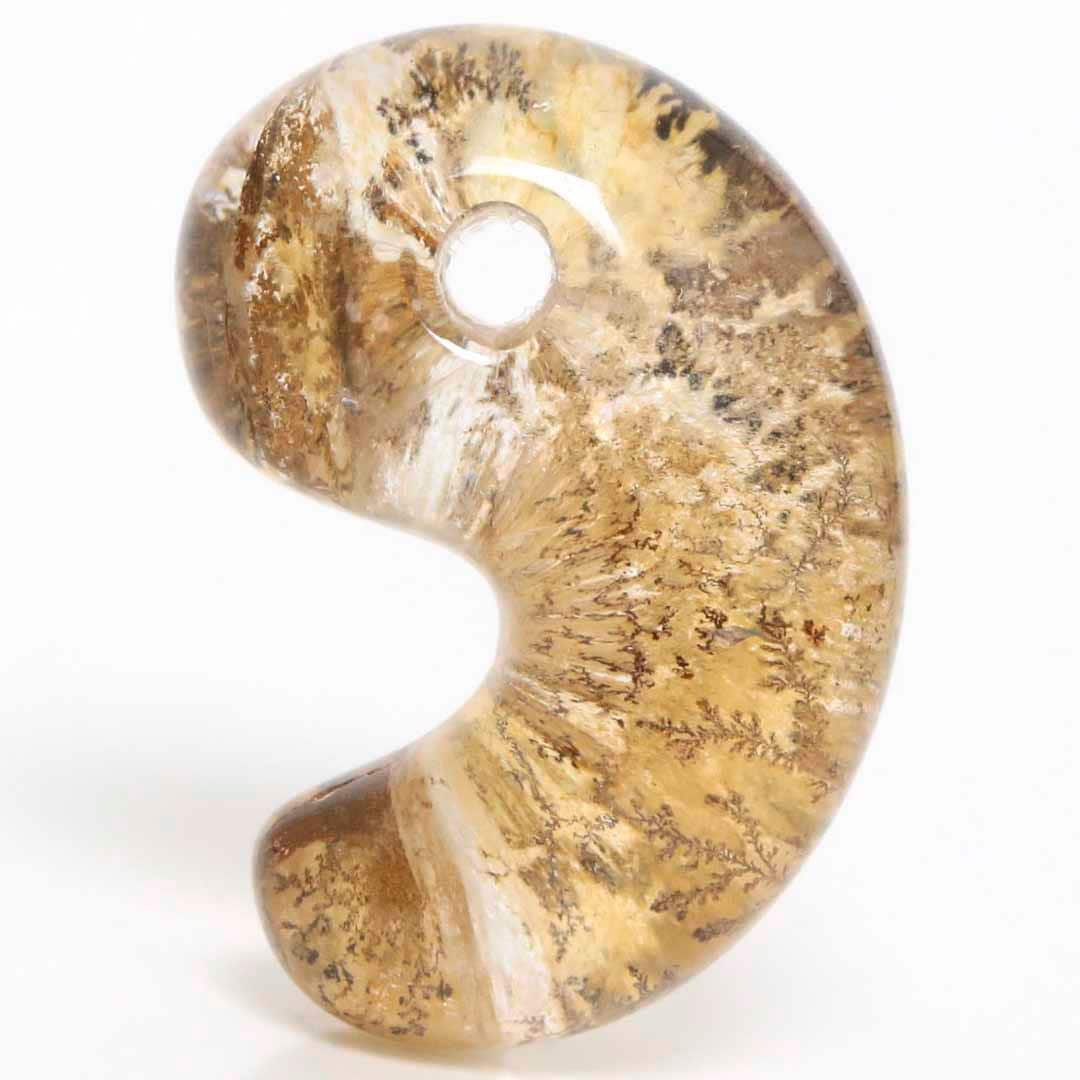Close-up of a dendritic quartz Izumo-style magatama pendant with a drilled hole.