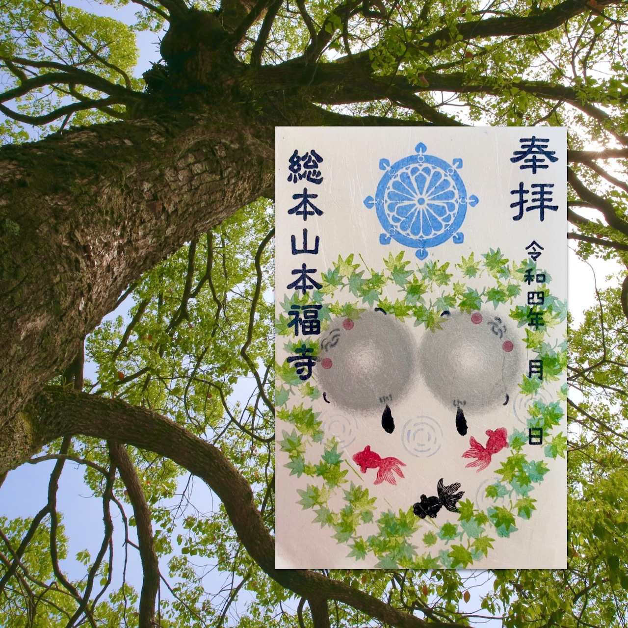 Greeting card depicting green maple leaves, two small gray jizo figures, and red and black fish, shown over a tree background.