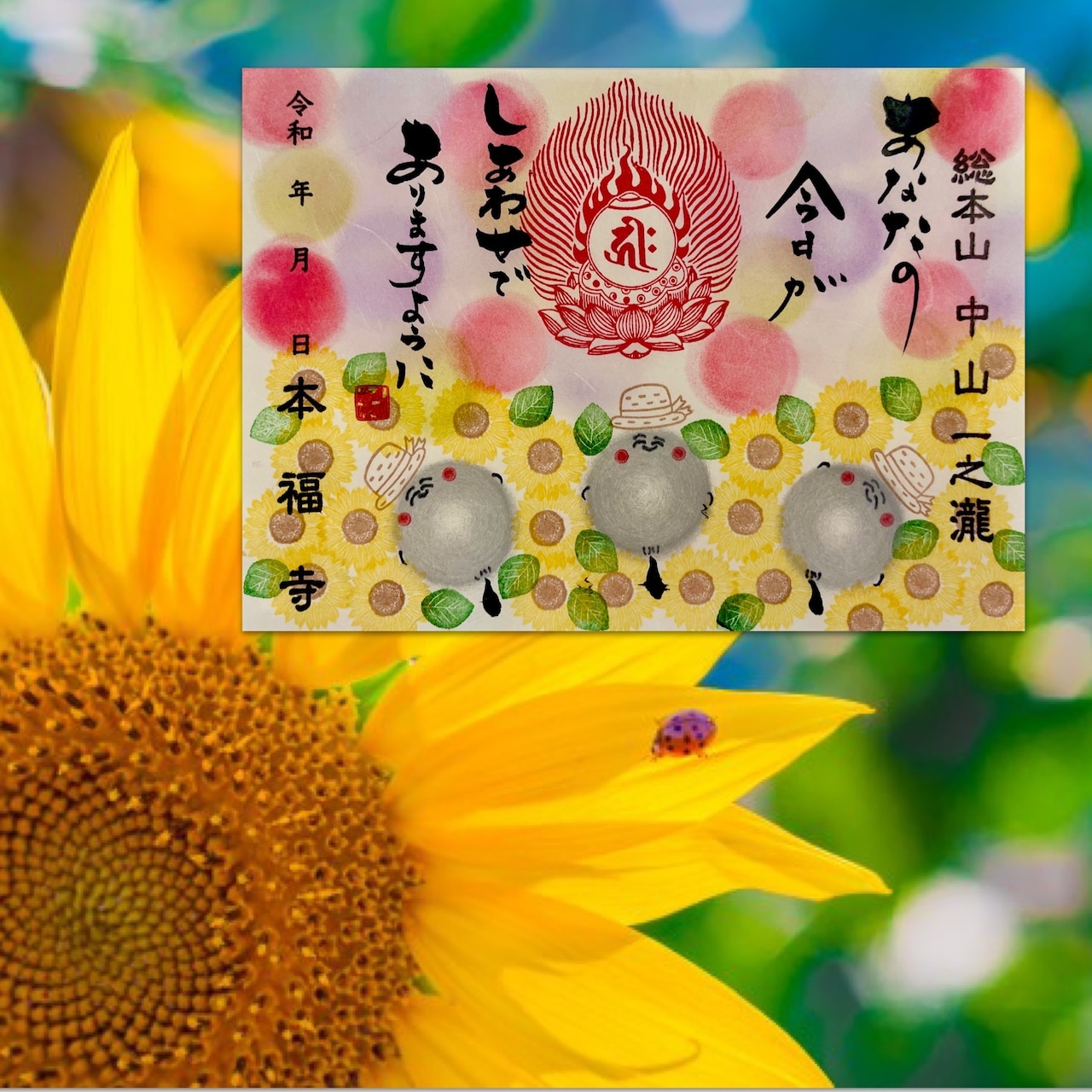 Greeting card showing small jizō figures, Japanese calligraphy, and decorative sunflowers over a sunflower photo background.