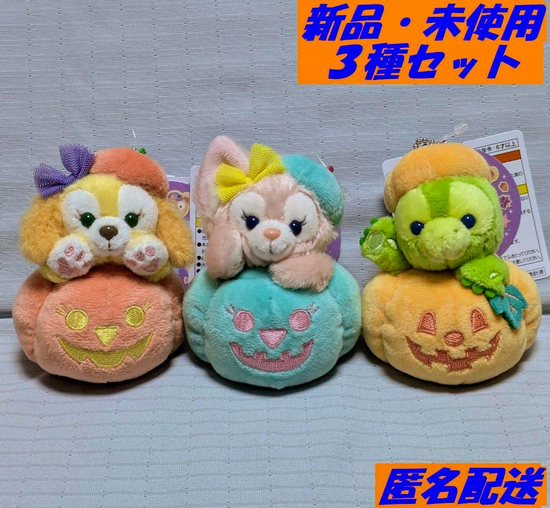 Three Halloween plush charms (リーナベル, オルメル, クッキーアン) sitting on pumpkin shapes arranged side by side on a light background.
