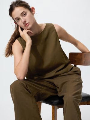 Seated model wearing a sleeveless linen-blend blouse.