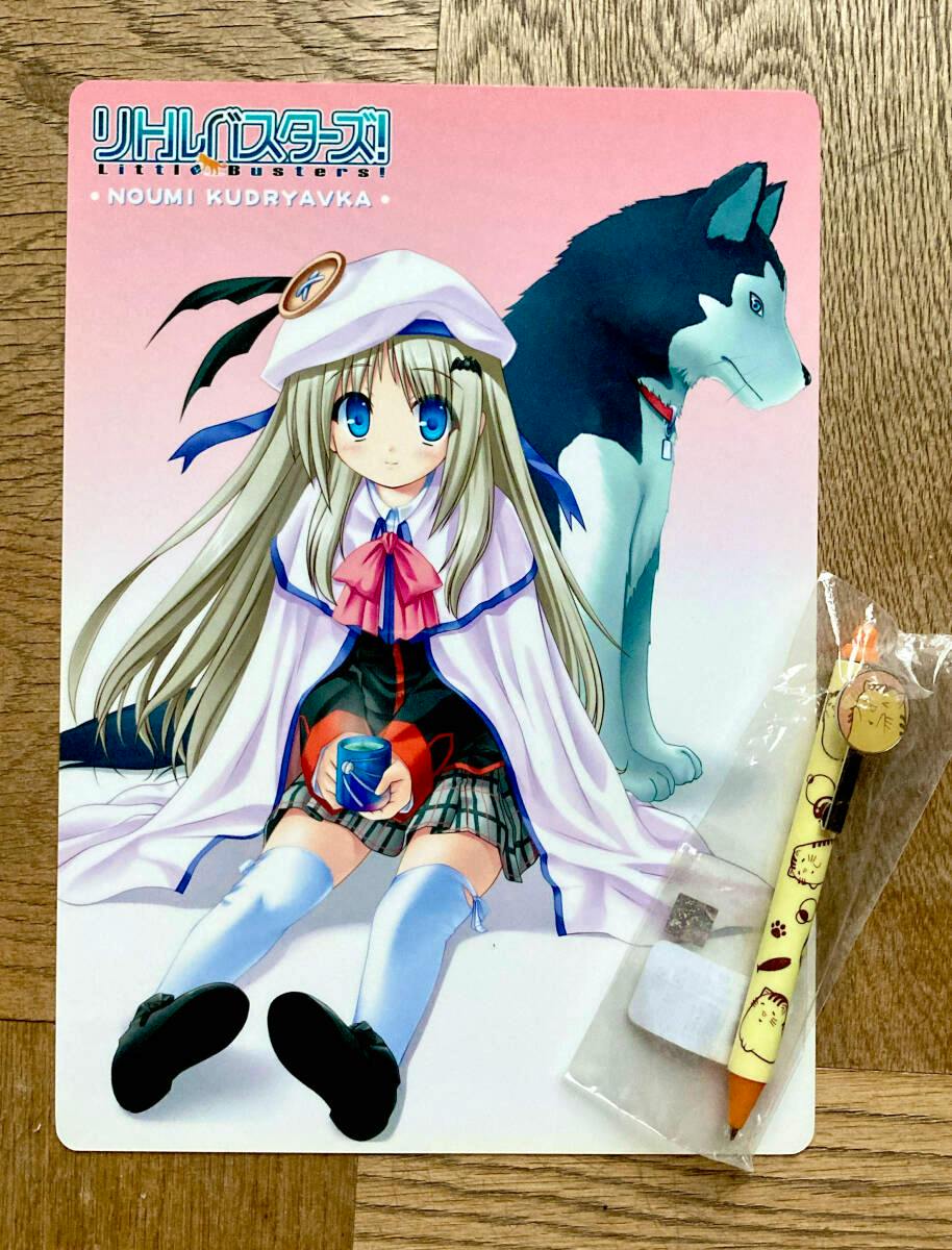 A clear file folder depicting the Little Busters character Noumi Kudryavka sitting with a dog, photographed on a wooden surface with a pen at the right.