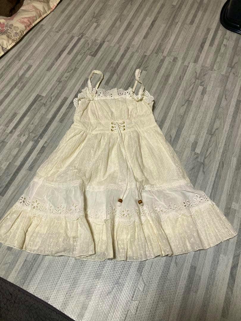 LIZ LISA white sleeveless mini dress laid flat showing the front with lace trim and waist ties.
