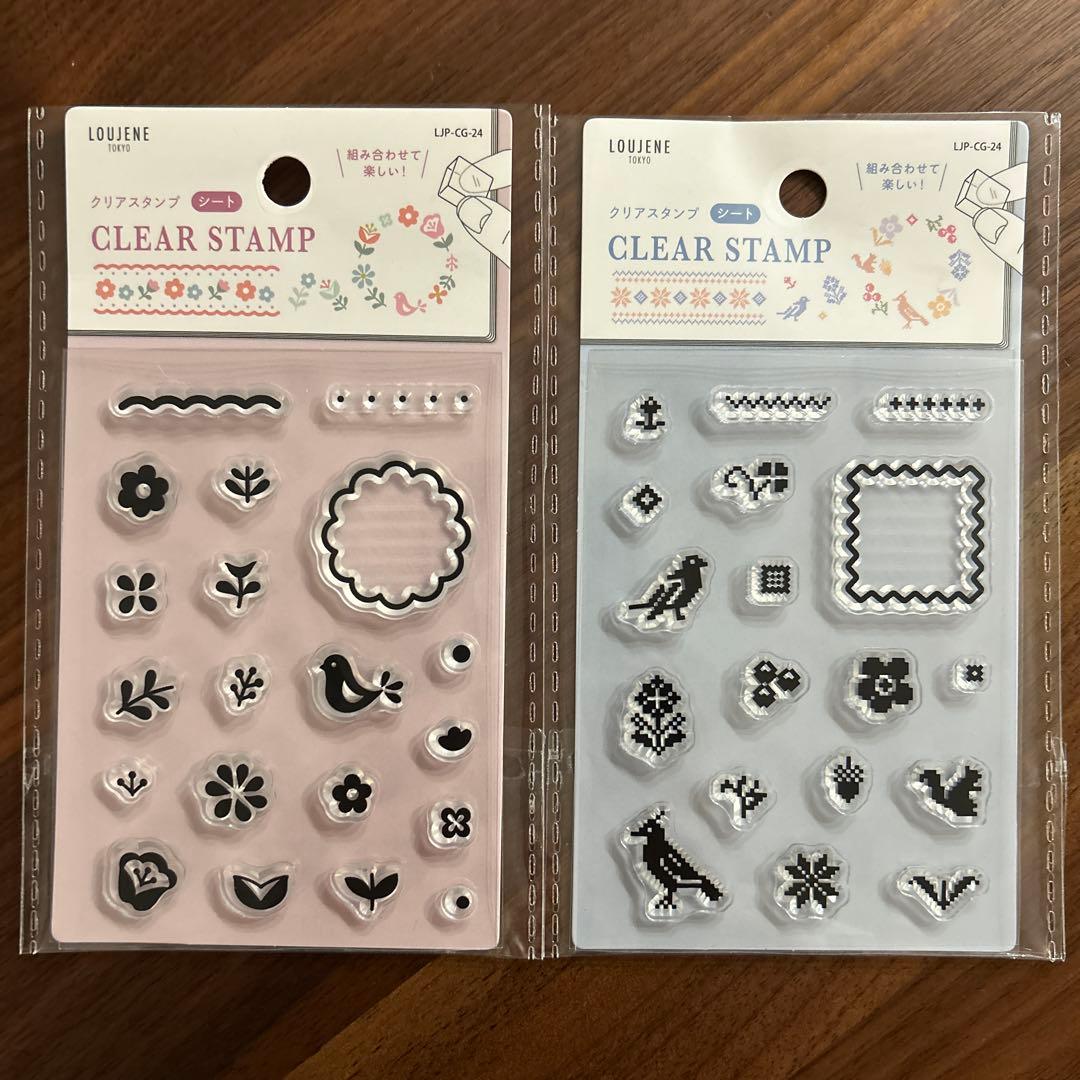 Photo of two packaged clear stamp sheets showing small floral and bird designs on a wooden surface.