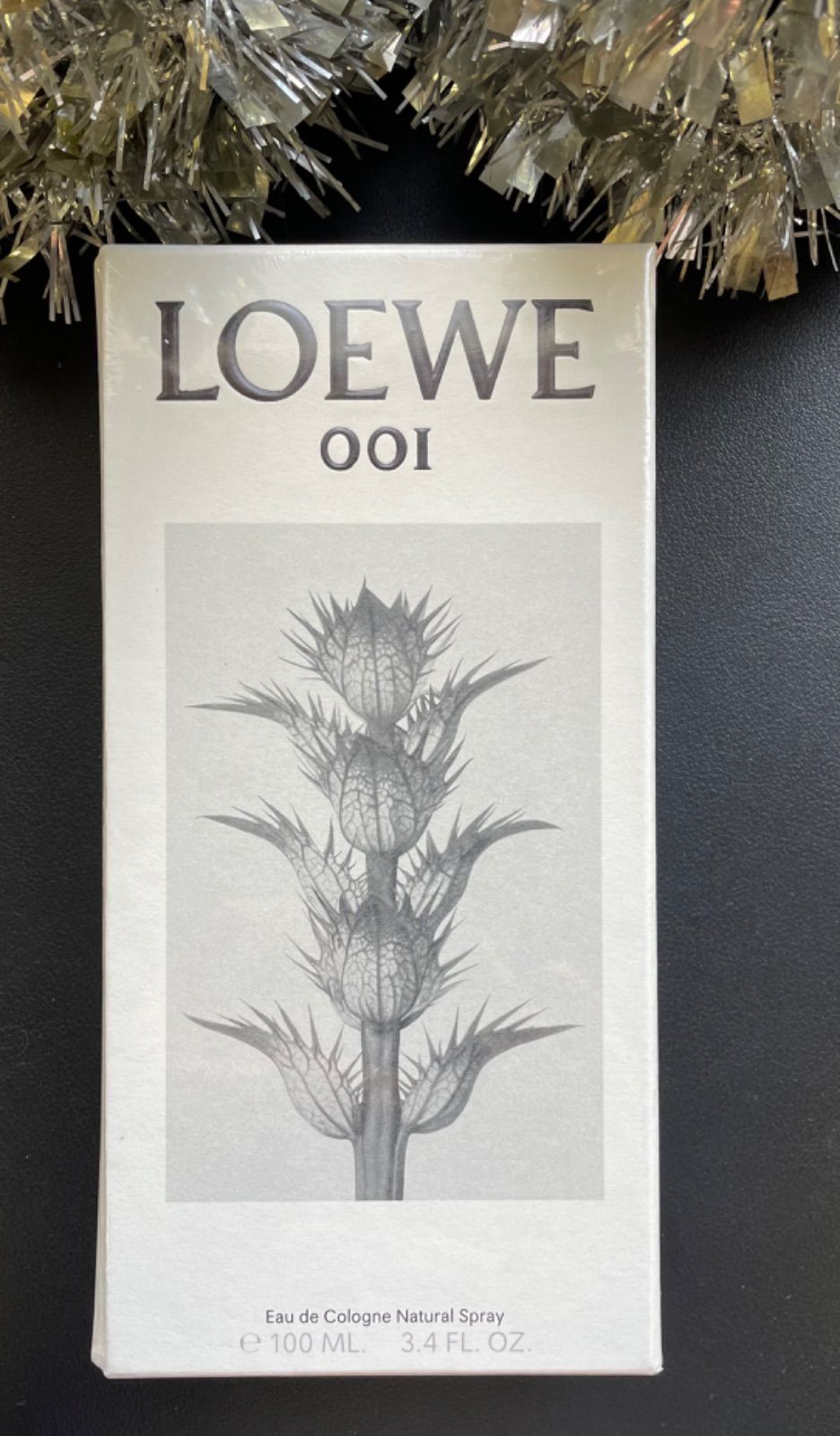 Front view of a LOEWE 001 Eau de Cologne 100 ml box showing the brand name and botanical illustration.