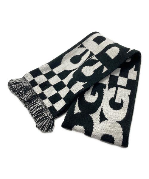 Black and white acrylic scarf showing large logo lettering, a checkerboard section, and fringed ends.