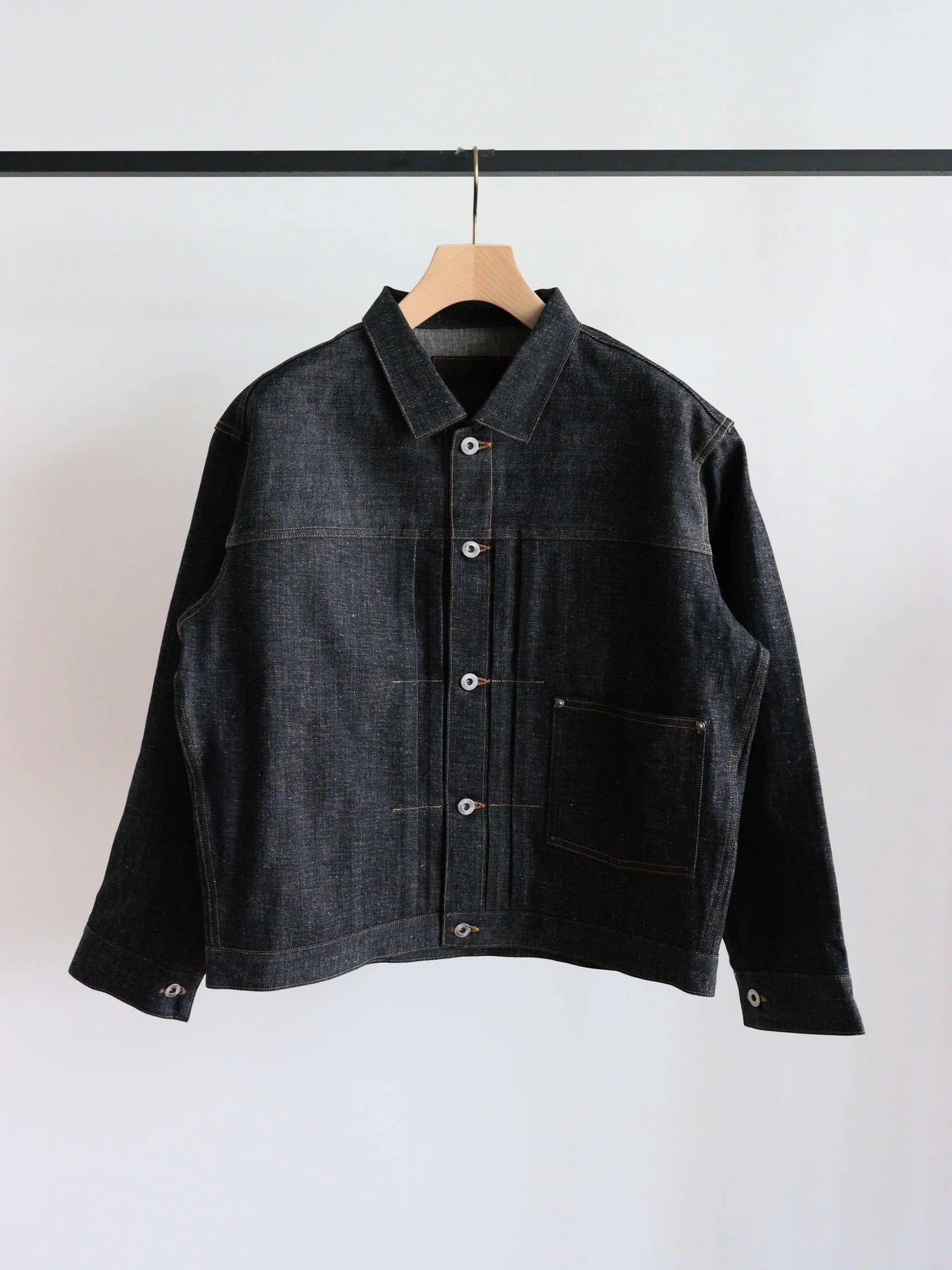Front view of a men's Lot.703 denim jacket hanging on a hanger against a white background.