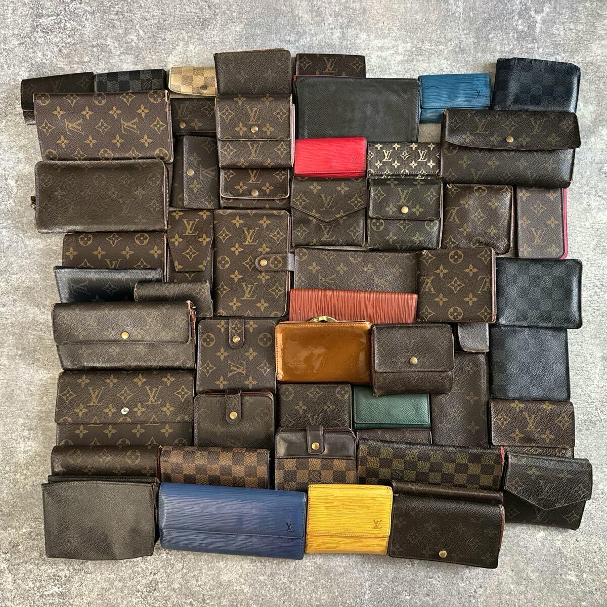 Assorted Louis Vuitton wallets and small canvas leather goods in monogram, Damier, and Epi patterns arranged flat on a surface.