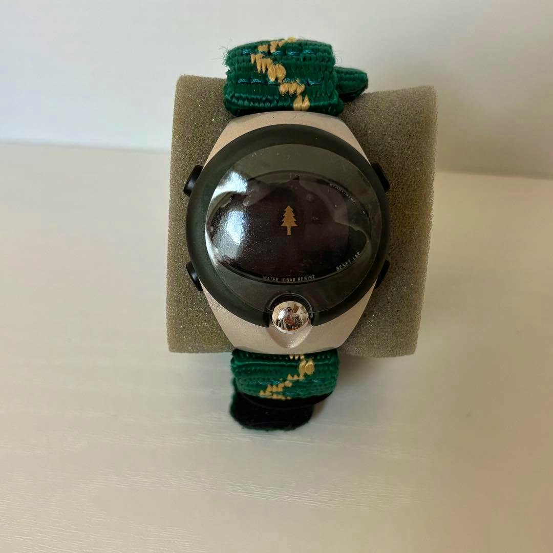 Front view of the Lotte 50th anniversary Seiko Alba memorial wristwatch with a green fabric strap displayed on foam.