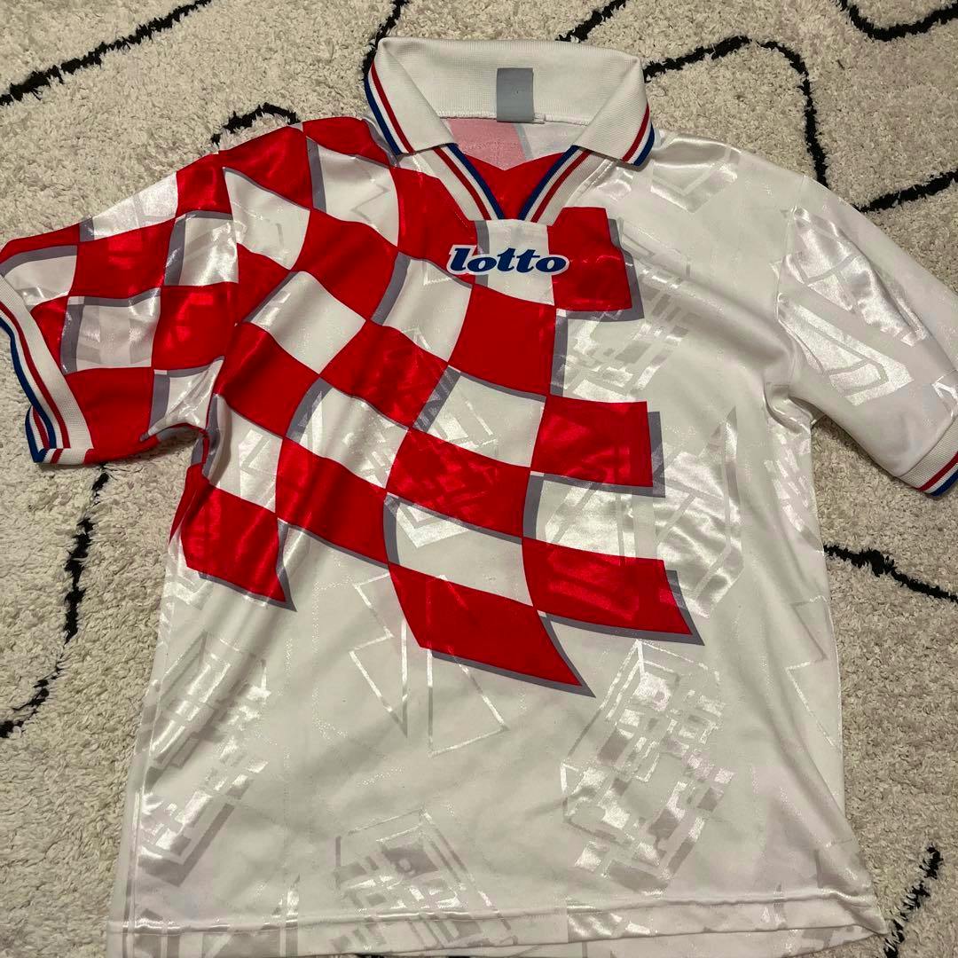 Lotto 1990s Croatia soccer jersey in white with a red checkerboard pattern laid flat on a rug.