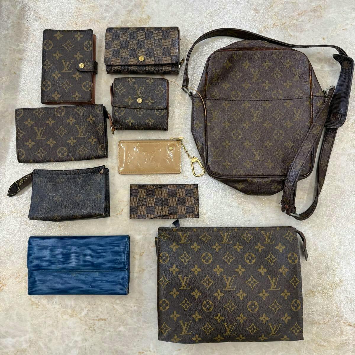 Flat lay of multiple Louis Vuitton monogram and Damier wallets, pouches, and a shoulder bag arranged on a light surface.
