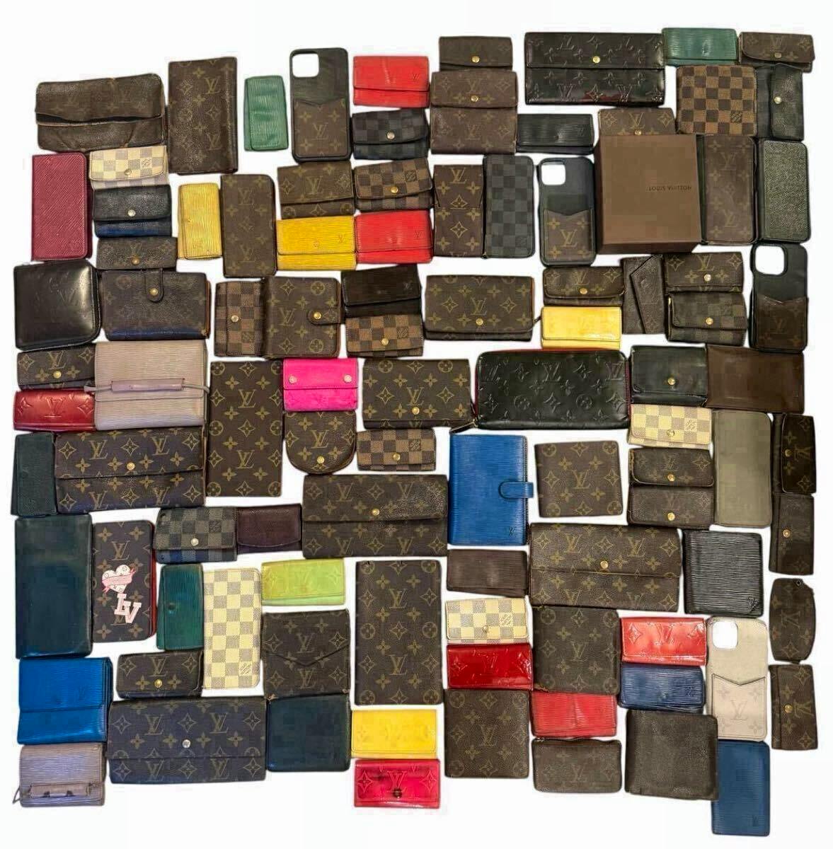 Many Louis Vuitton wallets, key cases, and small leather goods arranged on a white background.