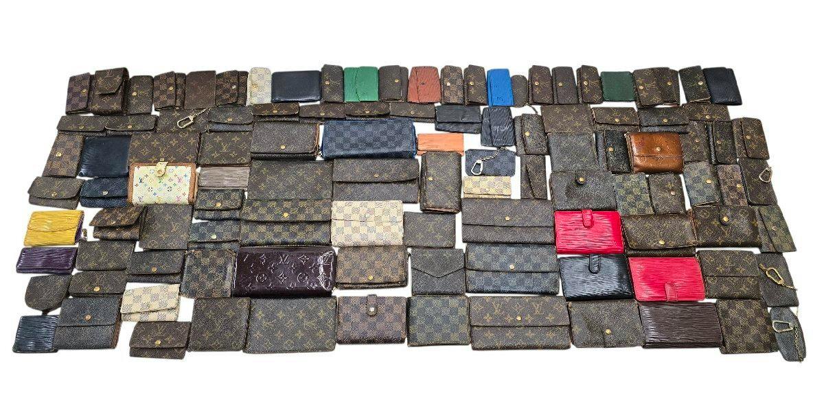 108-piece set of Louis Vuitton wallets and small leather cases laid out on a white background.