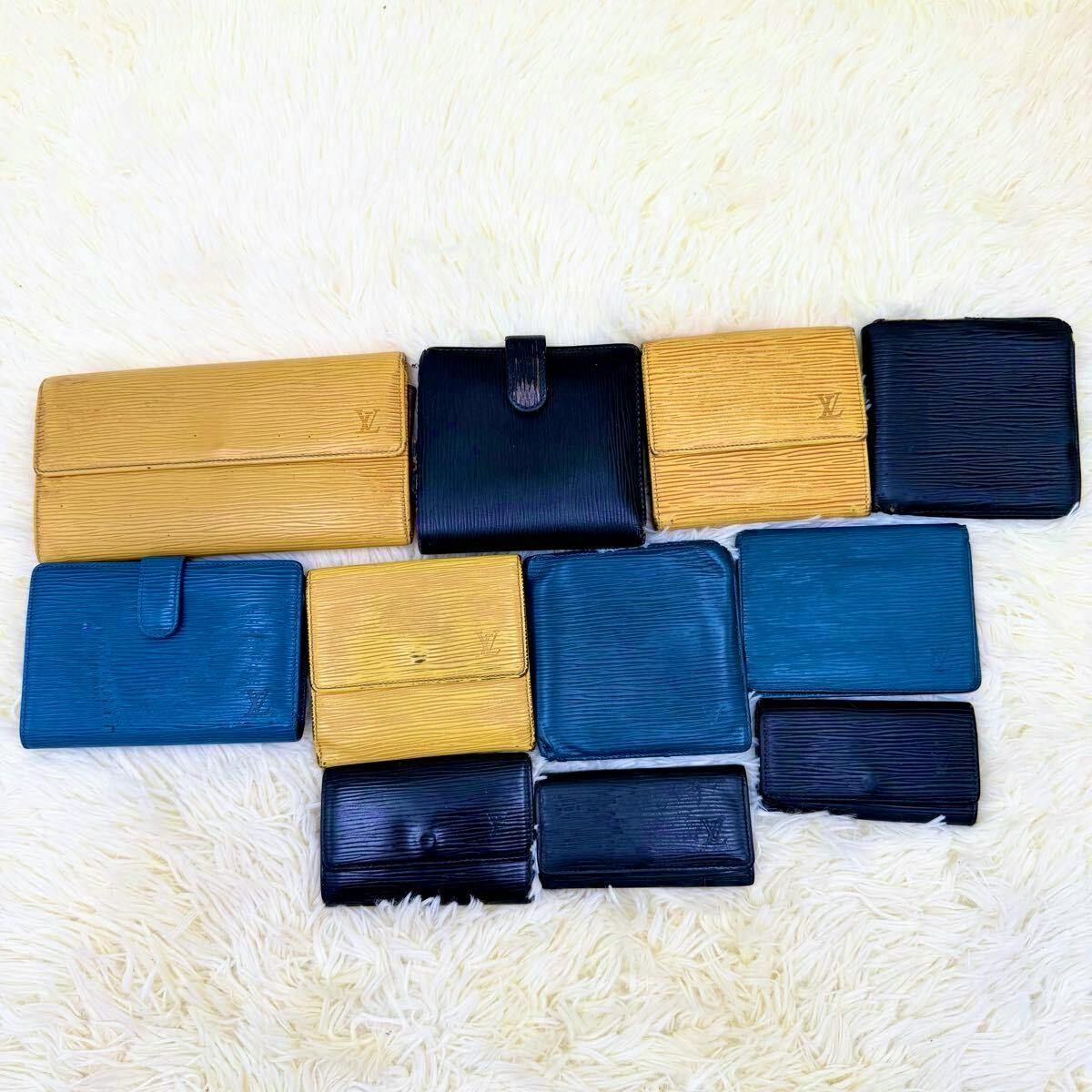 Multiple Louis Vuitton Epi wallets, card cases, and coin cases in various colors arranged on a light fur surface.