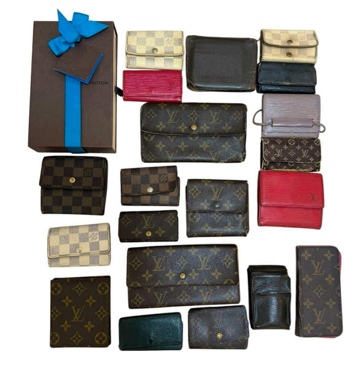 Top-down photo showing a set of Louis Vuitton wallets, key cases, and a boxed item arranged on a white background.