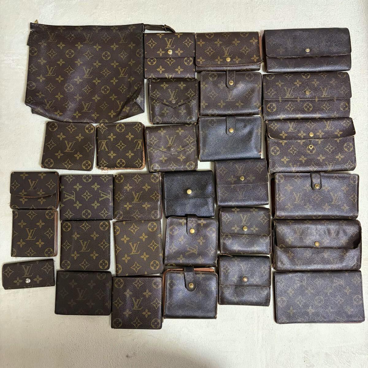 Multiple Louis Vuitton monogram wallets and small leather pouches arranged on a light background.