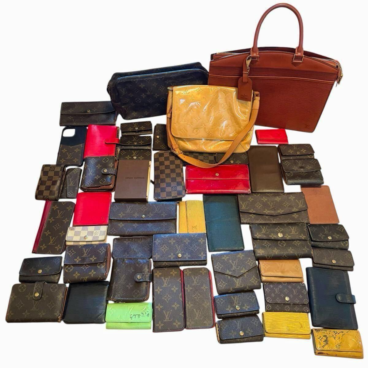 A laid-out 50-piece assortment of Louis Vuitton wallets, key cases, and bags in monogram, Damier, and Épi styles on a white background.