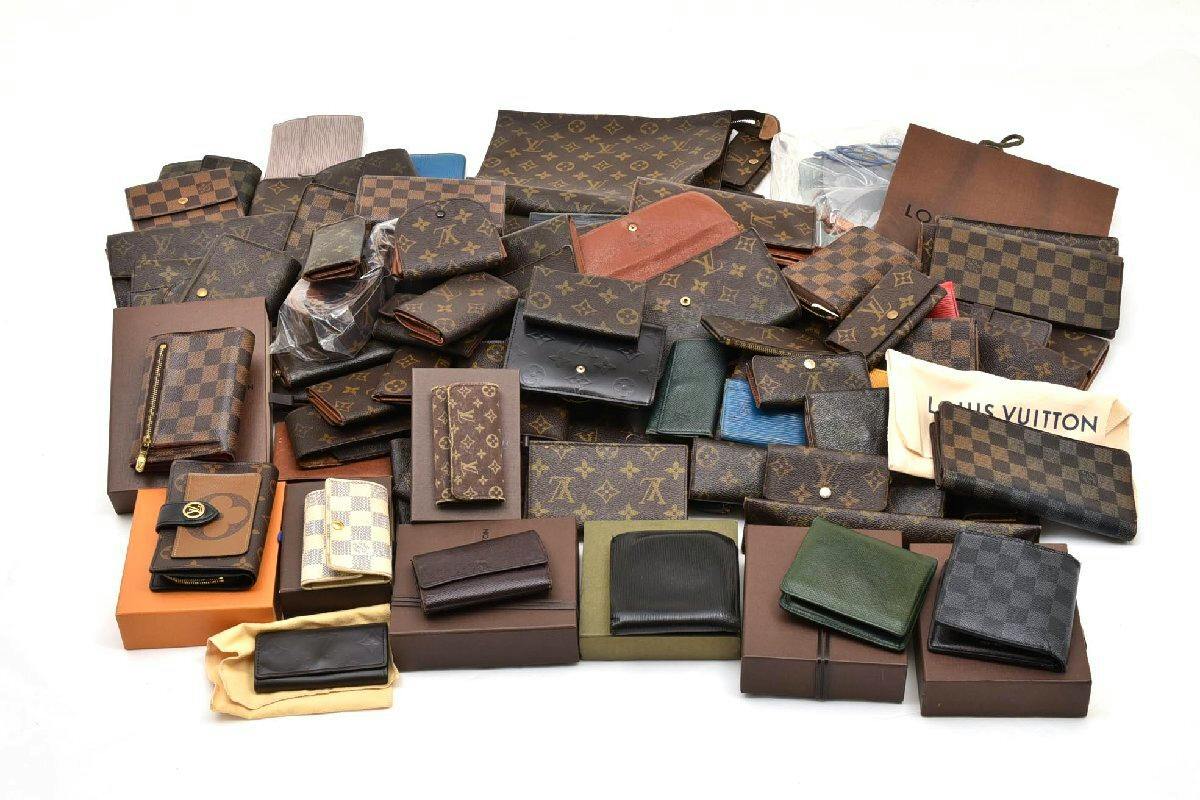 A large assortment of Louis Vuitton small leather goods including wallets, key cases, and pouches arranged on a white background.