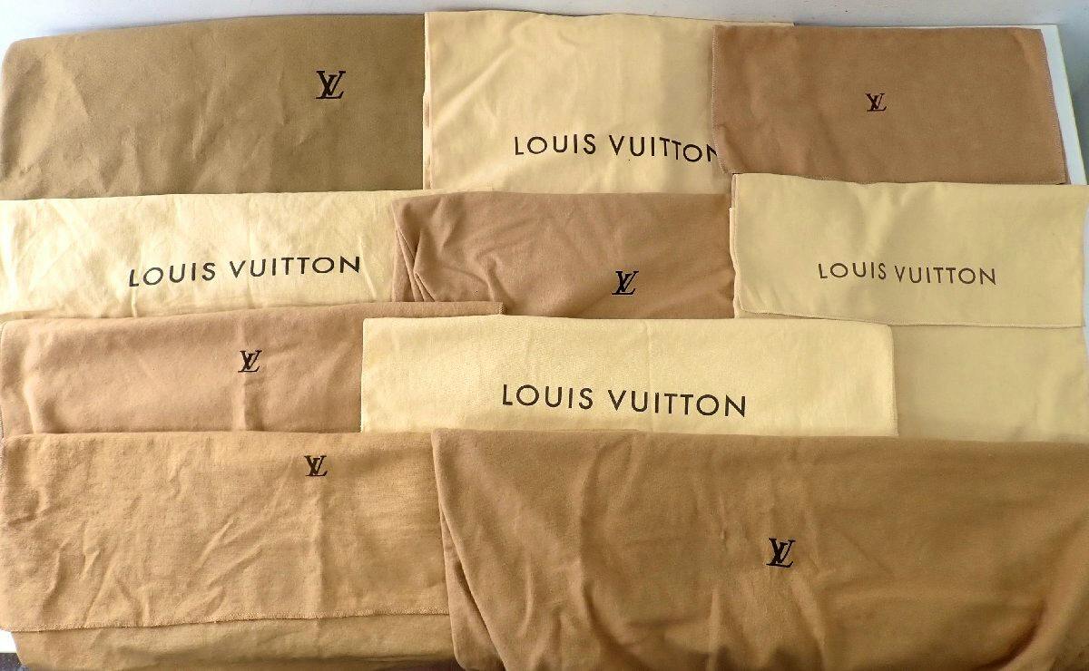 Multiple beige and brown Louis Vuitton fabric dust bags of various sizes laid flat, showing 'LOUIS VUITTON' text and LV logos.