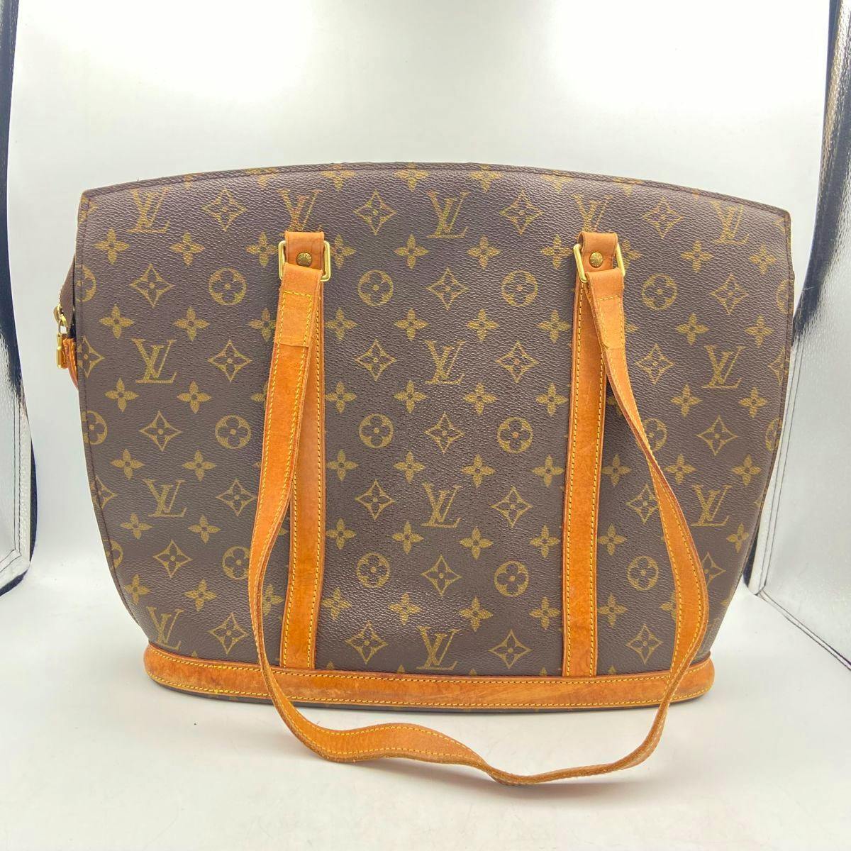 Front view of a Louis Vuitton Monogram Babylon M51102 tote bag with leather shoulder straps.