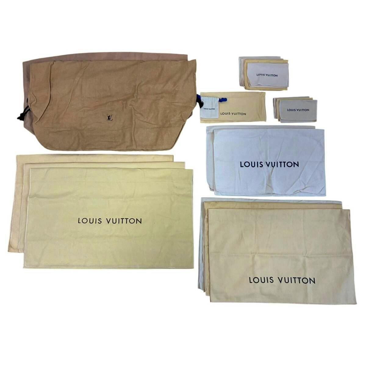 Multiple Louis Vuitton cotton dust bags and pouches in beige, brown, white, and yellow laid flat showing the LOUIS VUITTON logos.