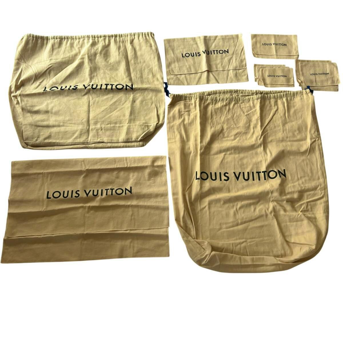 Several beige Louis Vuitton cotton dust bags of various sizes laid flat showing the printed "LOUIS VUITTON" logo.