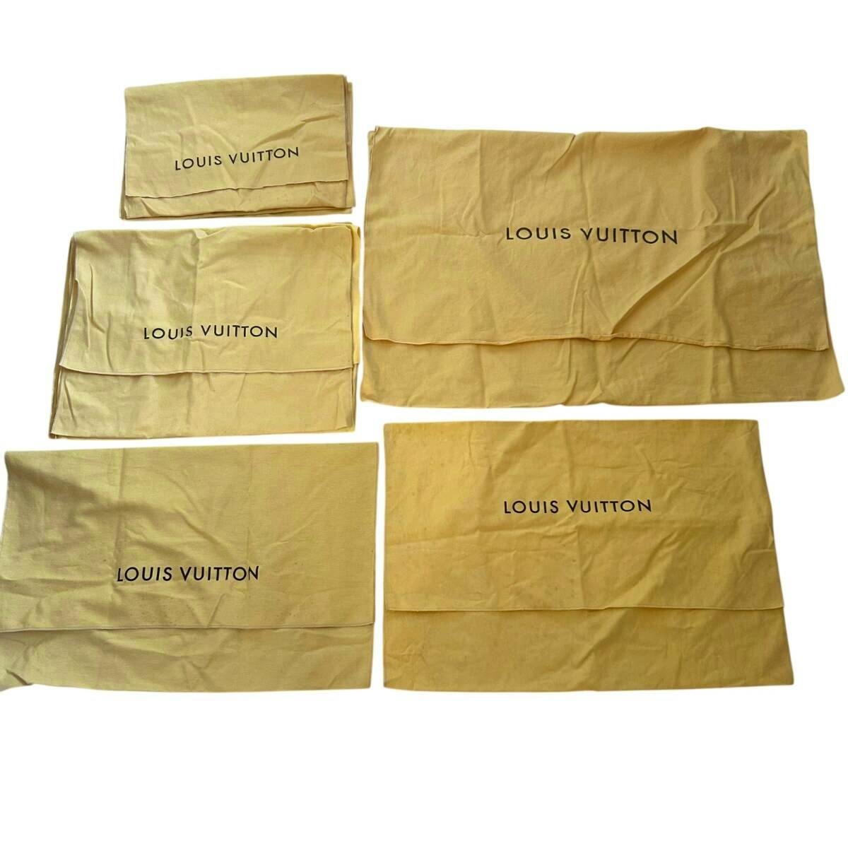 Multiple beige Louis Vuitton cotton dust bags laid flat showing the 'LOUIS VUITTON' print.