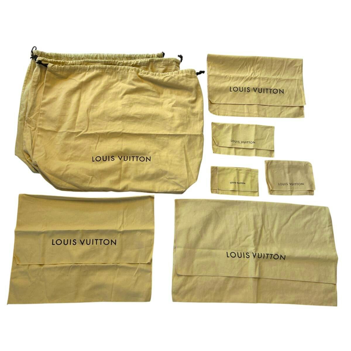 Multiple beige Louis Vuitton cotton dust bags and small pouches of various sizes arranged on a white background.