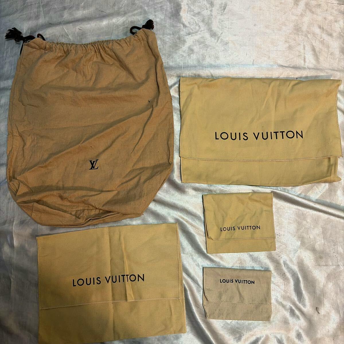 Five beige Louis Vuitton cotton dust bags of various sizes laid flat, showing 'LOUIS VUITTON' prints and an 'LV' logo.