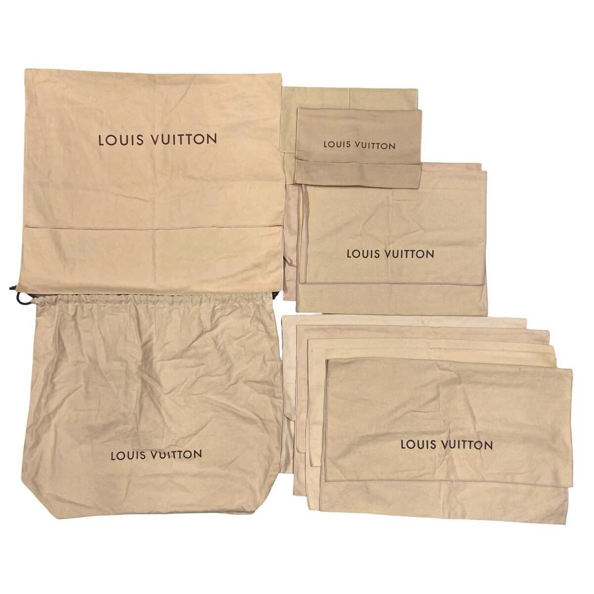 Several beige Louis Vuitton cotton dust bags of various sizes laid flat showing the LOUIS VUITTON logo.