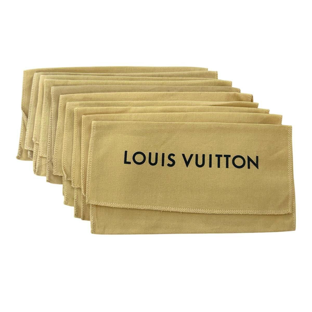 Several beige Louis Vuitton cotton dust bags stacked together with LOUIS VUITTON printed on the front.