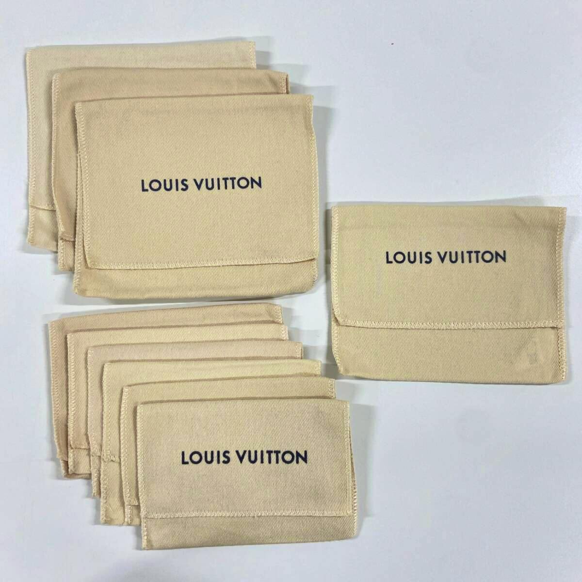 Several beige Louis Vuitton cotton dust bags with "LOUIS VUITTON" printed on them arranged on a white background.