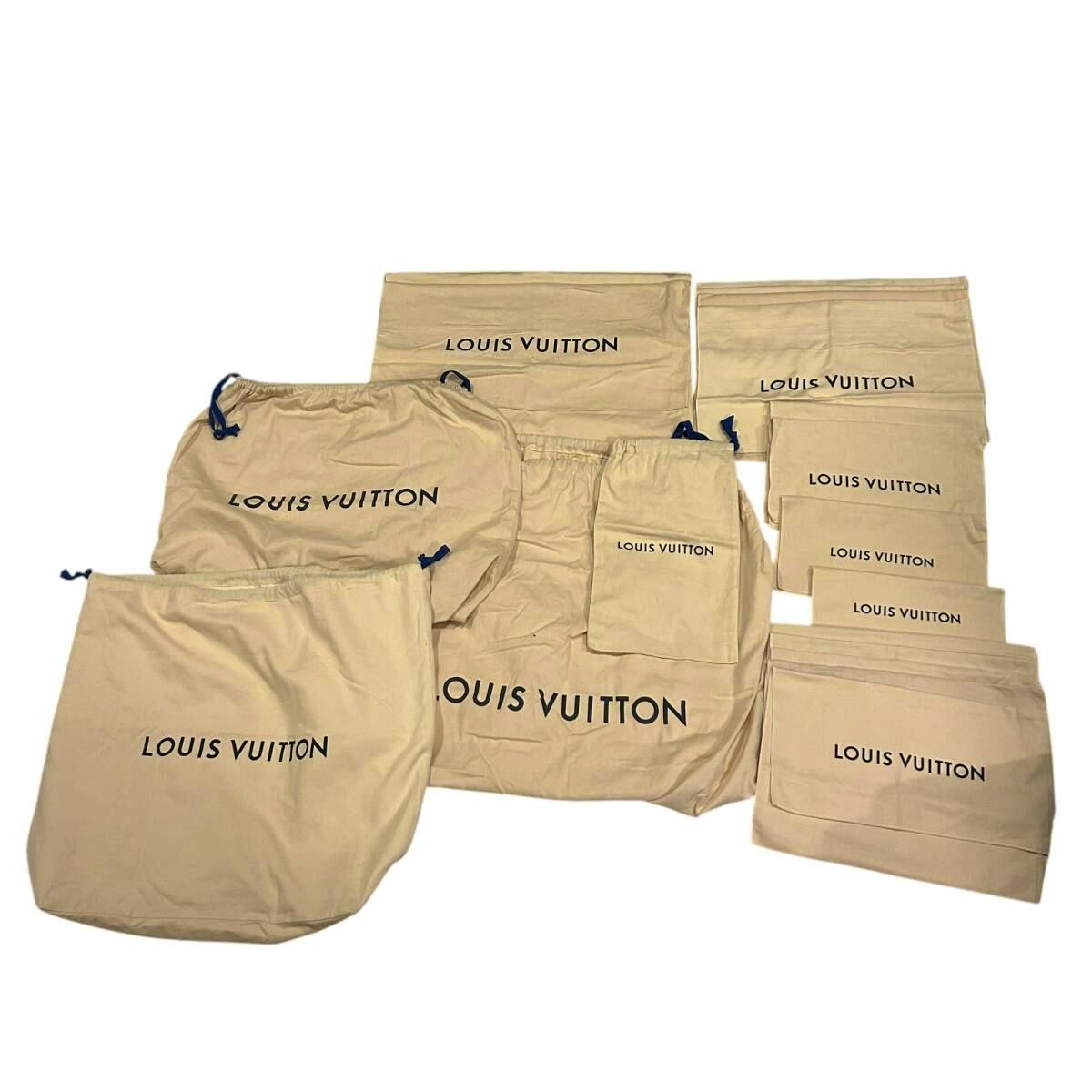 Several beige Louis Vuitton cotton dust bags in different sizes laid out flat showing the LOUIS VUITTON logo.