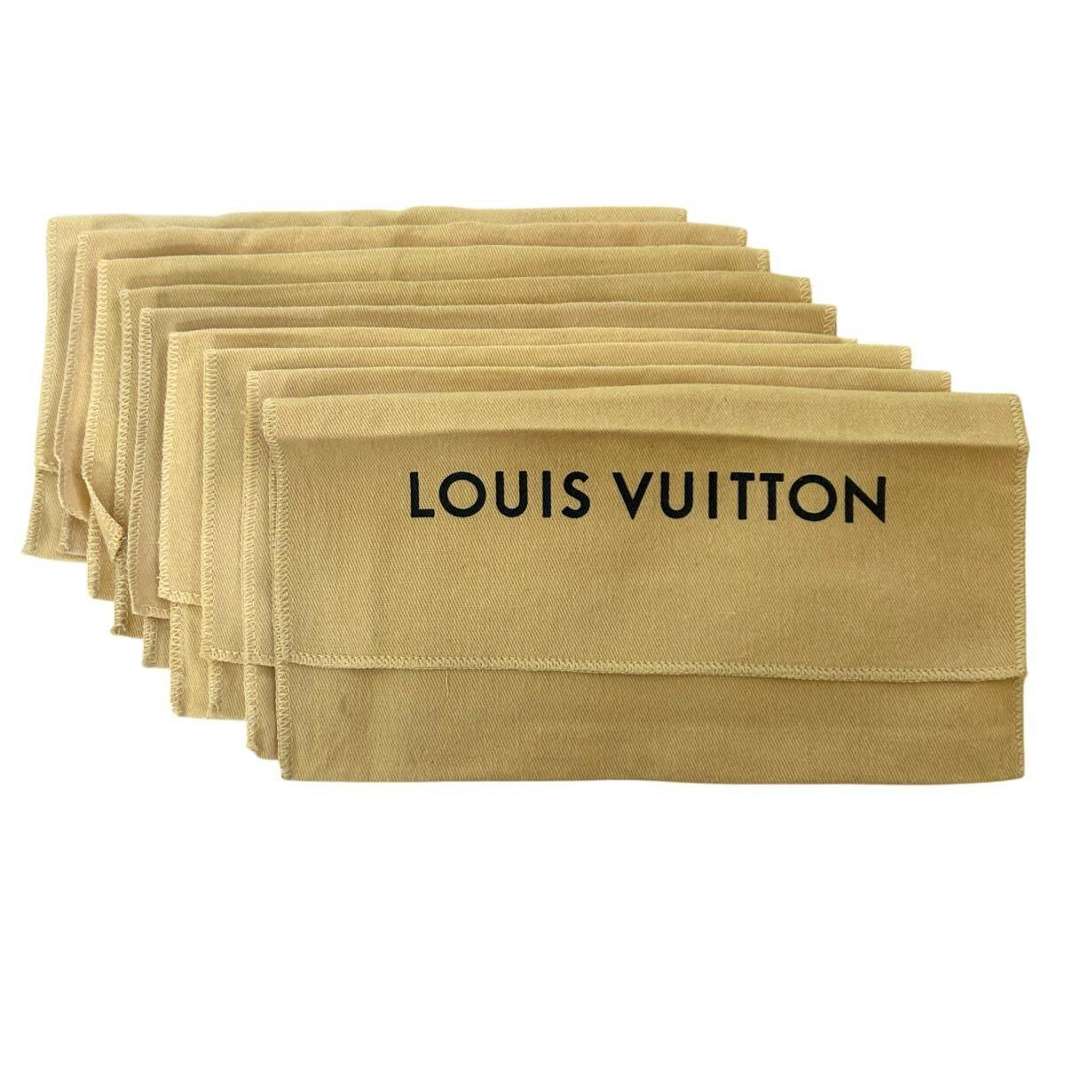 Several beige Louis Vuitton fabric dust bags stacked with "LOUIS VUITTON" printed on the front.